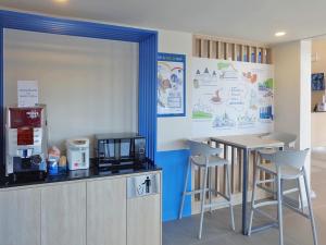 cocina con encimera, mesa y sillas en Hop Inn Nakhon Ratchasima City Center, en Nakhon Ratchasima