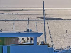 een boot in het water naast een waterlichaam bij Laguna Faro Suites - Adults Only & Free Beach in Grado