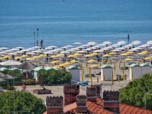 een strand met parasols en de oceaan bij Laguna Faro Suites - Adults Only & Free Beach in Grado