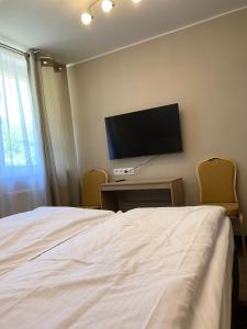 1 dormitorio con 1 cama y TV de pantalla plana en GRACJA, en Warszawa