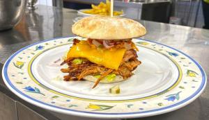 uma sanduíche num prato com um pão e batatas fritas em Hotel und Restaurant Nehrener Hof em Nehren