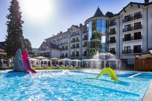 une piscine avec des toboggans en face d'un hôtel dans l'établissement Hotel Verde Montana Wellness & Spa, à Kudowa-Zdrój