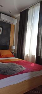 1 dormitorio con 2 camas y una ventana con cortinas en Apartment Travel hub ***, en Varaždin