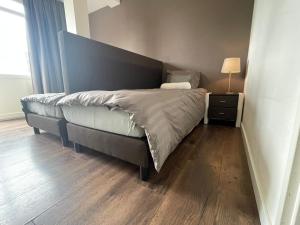 uma cama num quarto com piso em madeira em TopSleep Apartments 26-1 em Arnhem