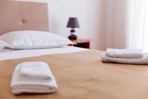 a bedroom with two beds with white towels on them at Castello Apartments in Ulcinj