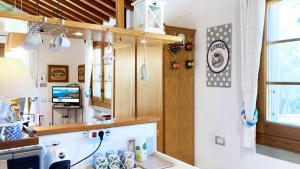 a kitchen with a counter and a tv in a room at Villetta I Due Pini - ArgonautiVacanze in Capoliveri