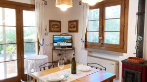 a dining room with a table with a television and windows at Villetta I Due Pini - ArgonautiVacanze in Capoliveri