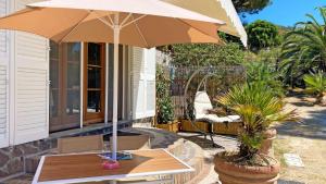 a table with an umbrella on a patio at Villetta I Due Pini - ArgonautiVacanze in Capoliveri