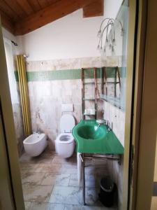 La salle de bains est pourvue d'un lavabo vert et de toilettes. dans l'établissement Casamare Hotel, à San Vincenzo