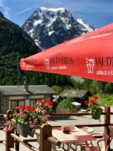 um guarda-chuva vermelho sentado em cima de uma mesa com flores em Hotel du Pigne em Arolla