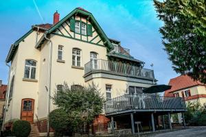 a large white house with a green roof and balconies at Traumhaft wohnen in Jugendstilvilla in Speyer