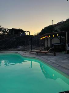 une piscine d'eau bleue devant une maison dans l'établissement Quinta do Cobral, à Oliveira do Hospital