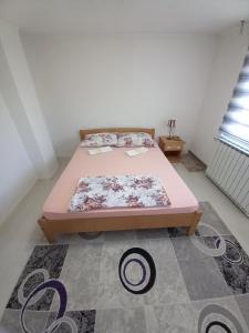 ein Schlafzimmer mit einem rosa Bett und einem Teppich in der Unterkunft Apartment Maida in Dubrave Gornje