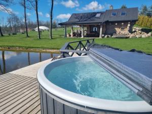 een hot tub op een terras naast een huis bij Pirties namelis ant ežero kranto in Trakai