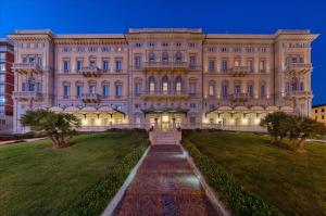 ein großes Gebäude mit einem Weg davor in der Unterkunft GH Palazzo Suite & SPA in Livorno