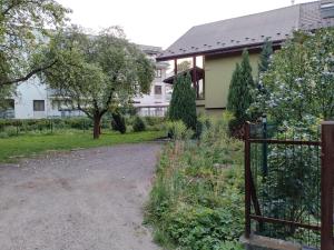 eine Auffahrt, die zu einem Haus mit einem Zaun führt in der Unterkunft Parkowa House in Krakau