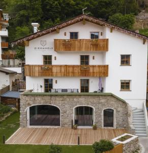 a house with a balcony on top of it at Garni Ziernheld in Malles Venosta