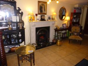 a living room with a fireplace and a table at Ben View Guesthouse in Clifden