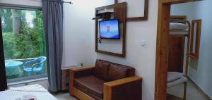 a room with a chair and a tv on a wall at Hotel Al Azeem in Ayubia