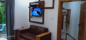 a room with a chair and a tv on a wall at Hotel Al Azeem in Ayubia