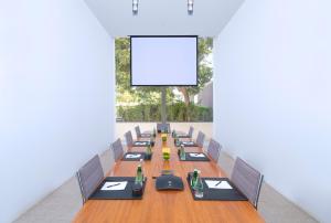 a long table with chairs and a blank screen at The Oberoi Beach Resort, Al Zorah in Ajman 