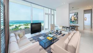 a living room with a couch and a flat screen tv at The Oberoi Beach Resort, Al Zorah in Ajman 