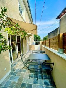 een picknicktafel en stoelen op een patio bij Villa Elisa M in Aubenas