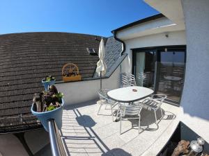 eine Terrasse mit einem Tisch und Stühlen auf dem Balkon in der Unterkunft Ferienwohnung Pauli in Mörbisch am See