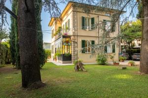 een huis met een boom ervoor bij Villa Romantica Wellness & SPA in Lucca