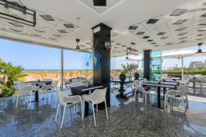 a restaurant with tables and chairs and a view of the ocean at Hotel Gritti in Lido di Jesolo