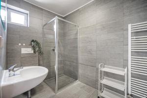 bagno con lavandino bianco e doccia di Penzion Village Peace #29 by Goodnite cz - U Libušky a Brno