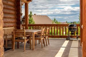 - une table et des chaises en bois sur une terrasse couverte avec barbecue dans l'établissement Tatranský Zrub, à Nová Lesná