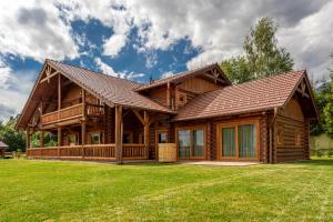 une cabane en rondins avec une grande cour et de l'herbe dans l'établissement Tatranský Zrub, à Nová Lesná