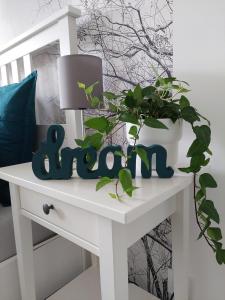 a white table with a plant on top of it at Gemütliches, voll ausgestattetes Apartment in Halle an der Saale