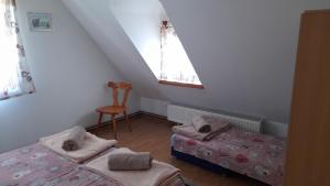 a bedroom with two beds and a chair and a window at Rooms Ma La in Karlovac