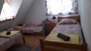 a bedroom with two beds and a chair in it at Rooms Ma La in Karlovac