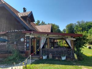 a house with a porch and a fence at Rooms Ma La in Karlovac