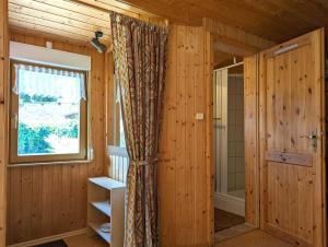 La salle de bains est pourvue de murs en bois, d'une fenêtre et d'une douche. dans l'établissement Gartenhaus Haufe, à Quedlinbourg