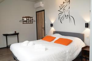 een slaapkamer met een bed met oranje kussens en een paard aan de muur bij SensUP à 5min de Pairi Daiza in Brugelette