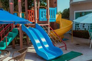 een speeltuin met een blauwe en gele glijbaan bij Hotel Paradiso del Sol in Cabo Frio