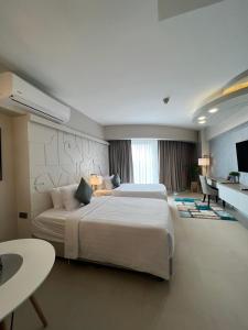 een hotelkamer met een groot bed en een tafel bij AEON SUITES STAYCATION managed by ARIA HOTEL in Davao City