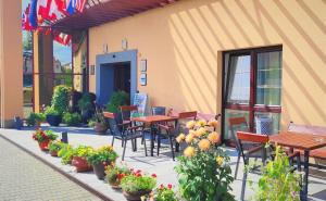 un patio extérieur avec des tables, des chaises et des fleurs dans l'établissement PRIMAVERA Hotel & Congress centre, à Plzeň