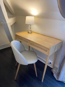 - un bureau dans une chambre avec une chaise et une lampe dans l'établissement Hotel l'Avenue, à Chantilly