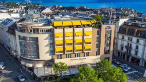 an overhead view of a building with yellow awnings at Studios Astra Hotel Vevey in Vevey