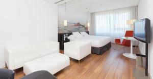 una camera d'albergo con letto e TV di Axor Barajas a Madrid