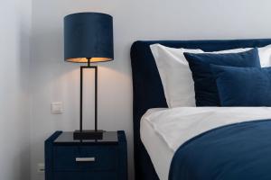 een lamp op een nachtkastje naast een bed bij VIP Apart Center Baden-Baden in Baden-Baden