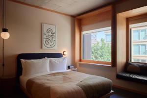 um quarto com uma cama e duas janelas em Ace Hotel Toronto em Toronto