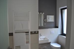 a white bathroom with a sink and a toilet at Boutique-Hotel "Stilvoll" in Andernach