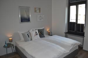 a bedroom with a bed with white sheets and pillows at Boutique-Hotel "Stilvoll" in Andernach