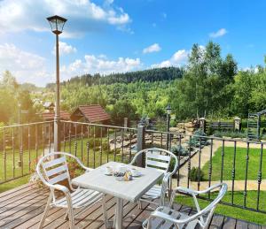 uma mesa e cadeiras num deque com vista em Villa Zoryany Dvir em Skhidnitsa